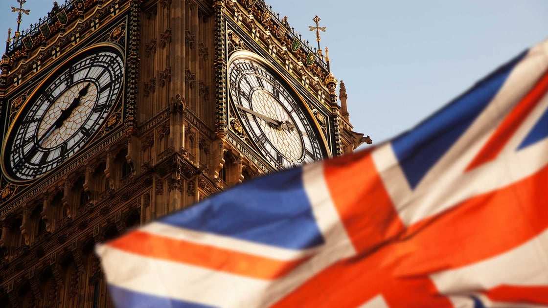 A Union Jack flag waves in front of Big Ben clock tower in London