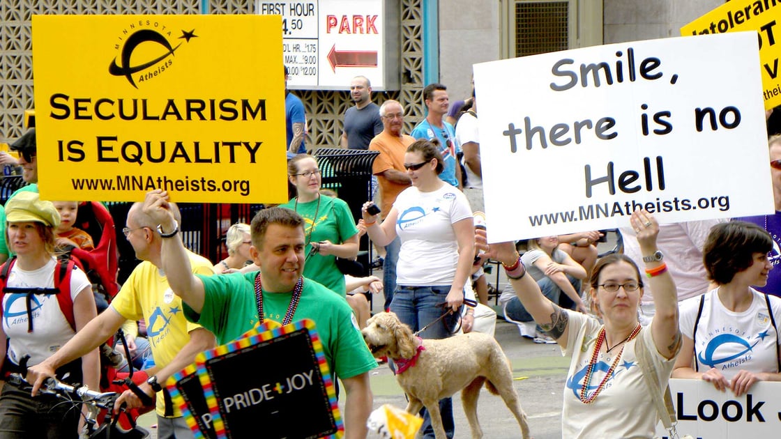Atheism advocates holding up signs during the Twin Cities pride parade